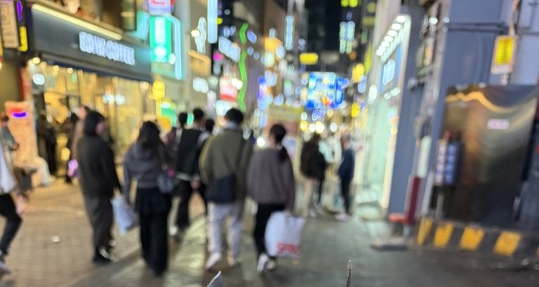 冬の夜の明洞。コートやダウンを着た人が行き交う通り