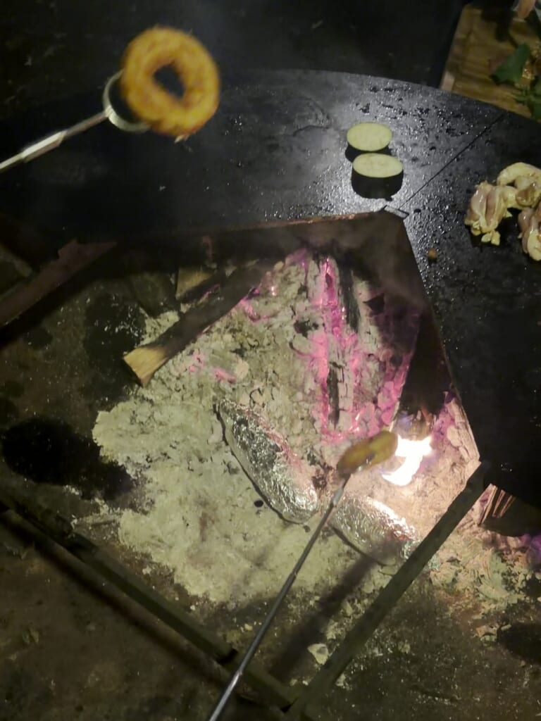 焼きマシュマロ用の長い串で焚き火にかざしたマシュマロ